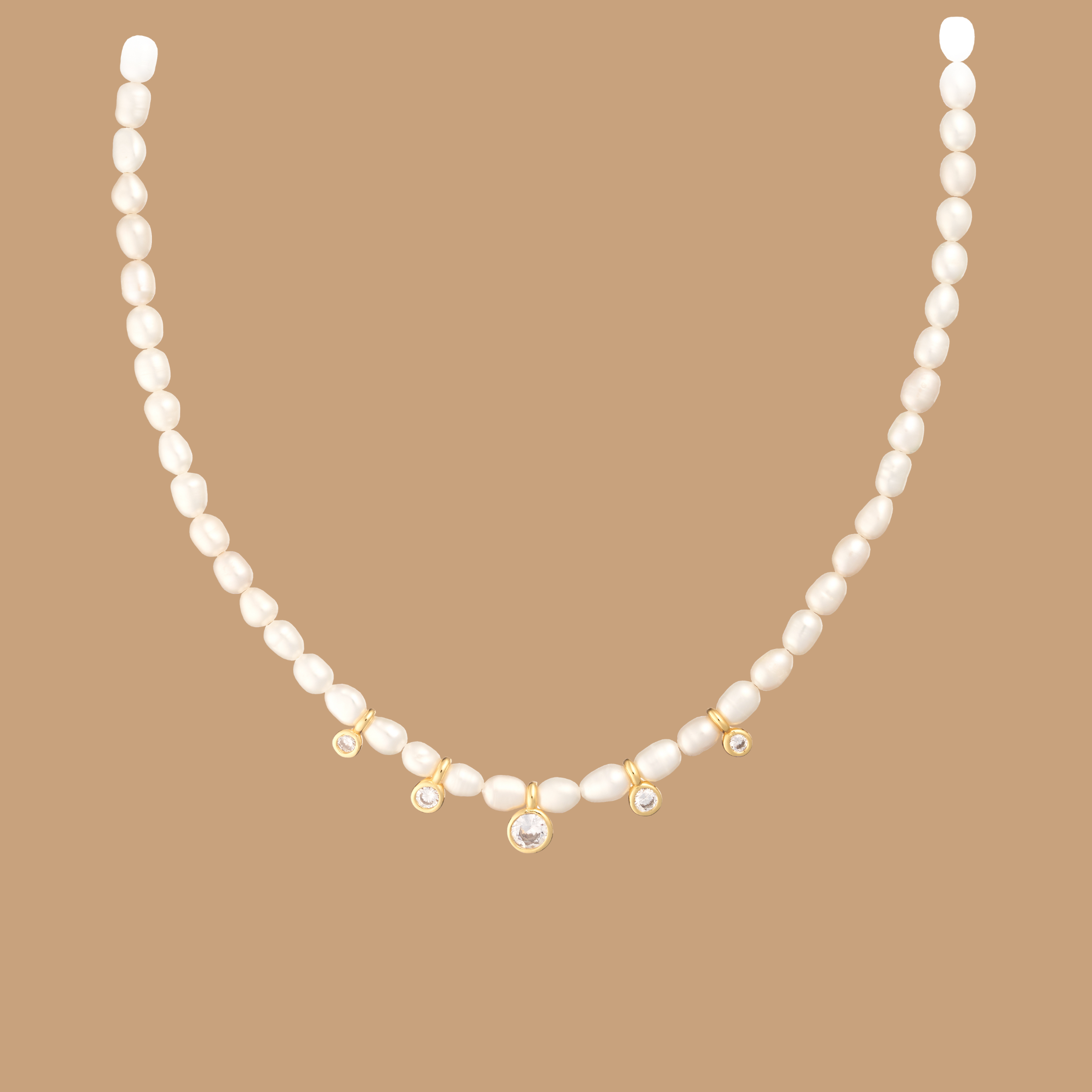 Gold and pearl necklace with delicate pendants on a beige background.
