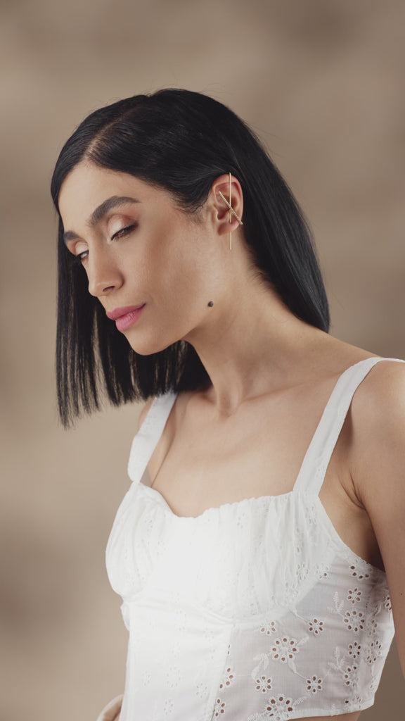 Gold bar earring with diamonds on ear, close-up detail